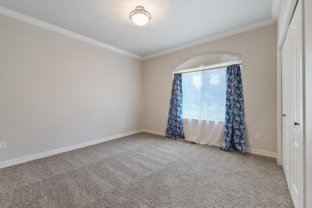 carpeted spare room featuring crown molding and baseboards