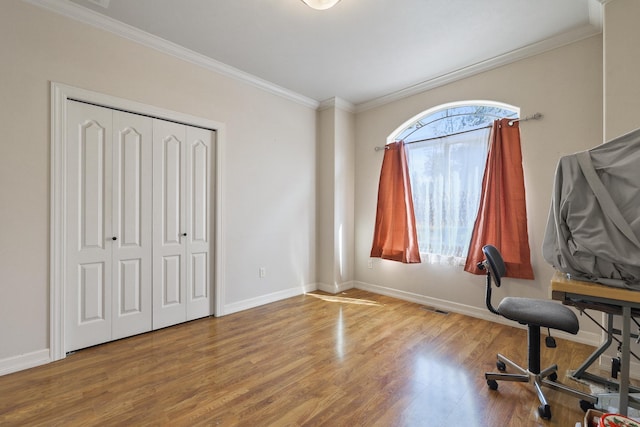 office space featuring visible vents, ornamental molding, baseboards, and wood finished floors