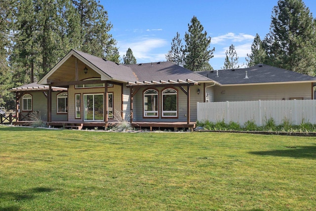 back of property featuring a wooden deck, a lawn, a pergola, and fence
