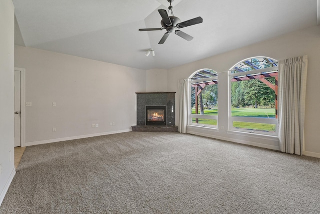 unfurnished living room with a premium fireplace, carpet floors, baseboards, and vaulted ceiling