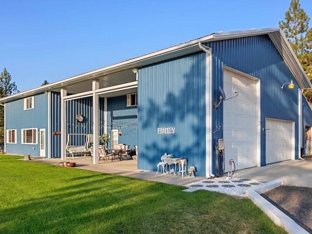 back of property featuring a garage and a yard