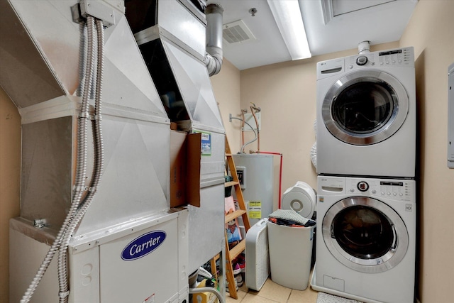 laundry area featuring light tile patterned flooring, stacked washing maching and dryer, and heating unit