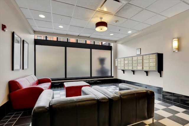 home theater room with mail boxes and a drop ceiling