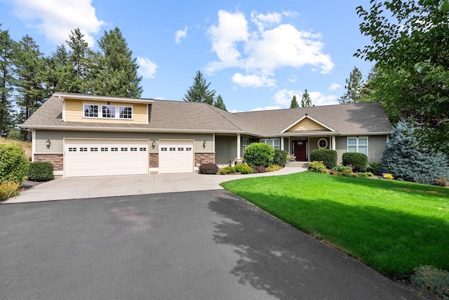 view of front facade with roof with shingles, a front yard, a garage, stone siding, and driveway