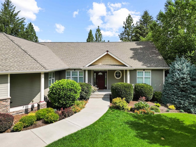 view of front of property featuring roof with shingles and a front lawn