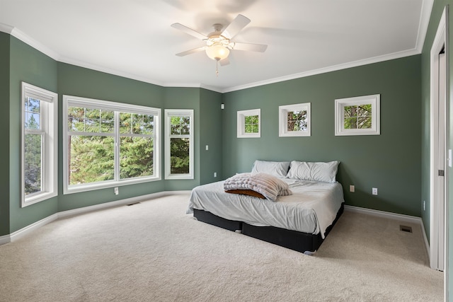 carpeted bedroom with ornamental molding, visible vents, baseboards, and a ceiling fan