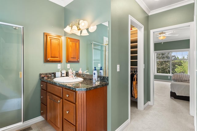 full bath with a stall shower, baseboards, ornamental molding, and vanity