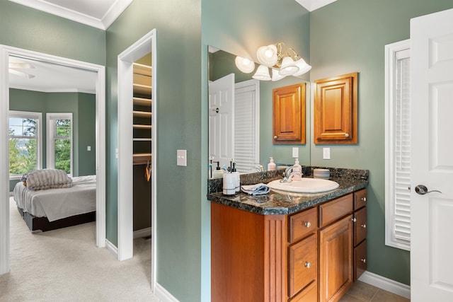 bathroom with ornamental molding, vanity, and baseboards