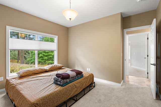 bedroom featuring light colored carpet and baseboards