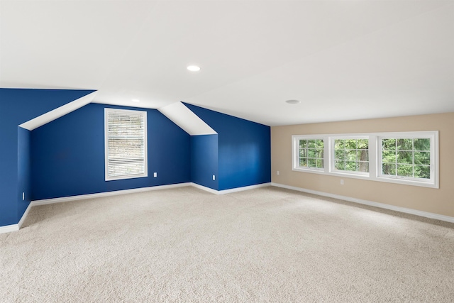 additional living space featuring lofted ceiling, recessed lighting, light colored carpet, and baseboards