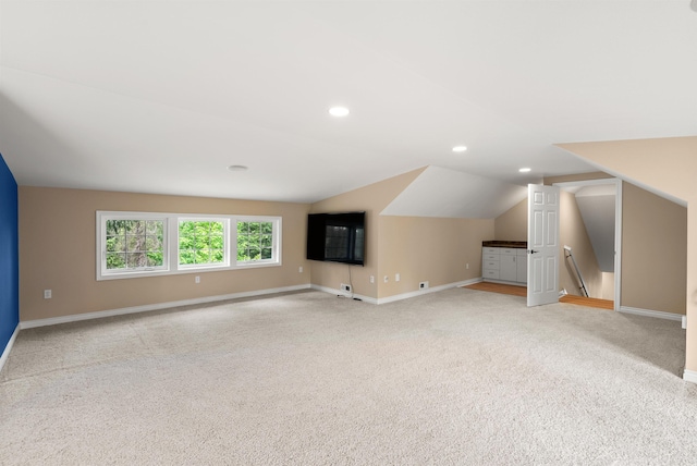 additional living space with lofted ceiling, light colored carpet, baseboards, and recessed lighting