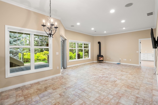 unfurnished living room with visible vents, baseboards, ornamental molding, a wood stove, and recessed lighting