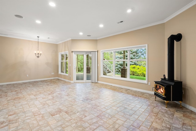 unfurnished living room with baseboards, visible vents, a wood stove, crown molding, and recessed lighting