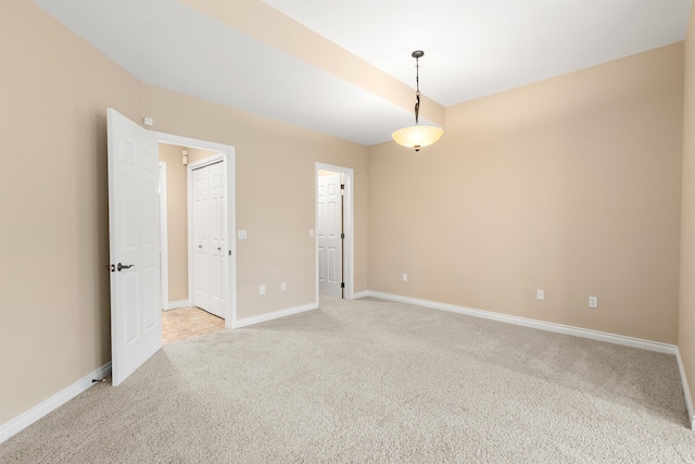 empty room with light colored carpet and baseboards