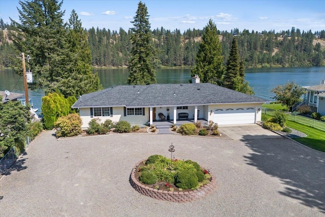 view of front of property featuring a garage and a water view