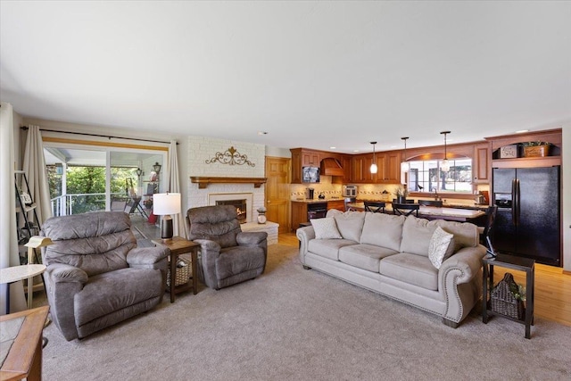 living room featuring recessed lighting, light colored carpet, and a fireplace