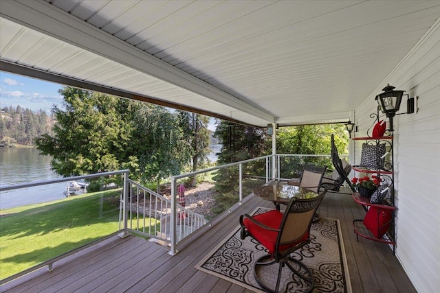 wooden deck with a water view and a yard