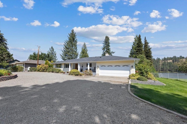 ranch-style house with a garage, a front yard, driveway, and fence