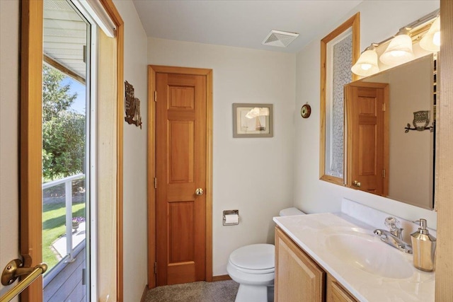 bathroom with a closet, vanity, and visible vents