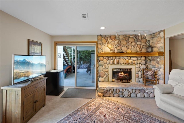 living room with light carpet, a fireplace, rail lighting, and visible vents