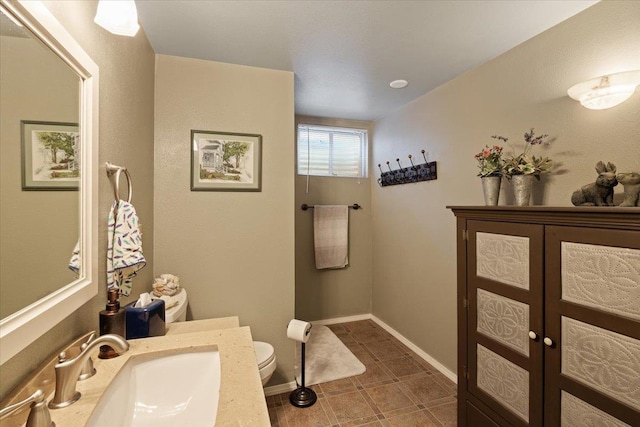 bathroom featuring vanity, toilet, and baseboards