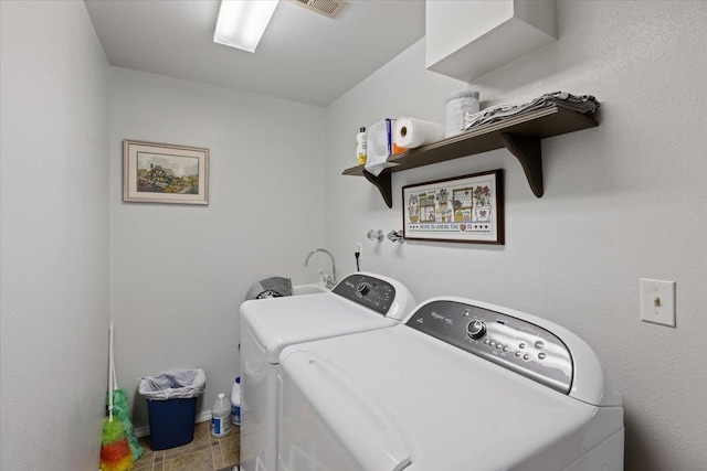 washroom featuring tile patterned flooring, laundry area, and washing machine and clothes dryer