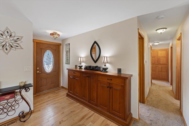 entryway with baseboards and light wood finished floors