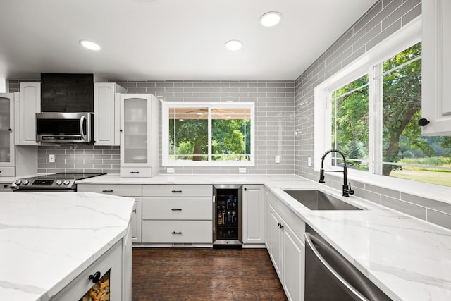 kitchen featuring sink, appliances with stainless steel finishes, beverage cooler, and a wealth of natural light