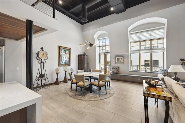 dining space featuring a high ceiling and ceiling fan