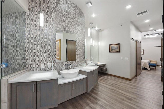 bathroom featuring tile walls, double sink vanity, and wood-type flooring