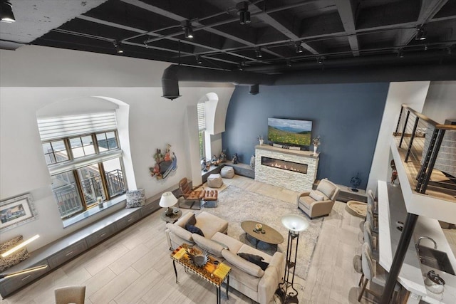 living room with hardwood / wood-style flooring, a high ceiling, and a fireplace