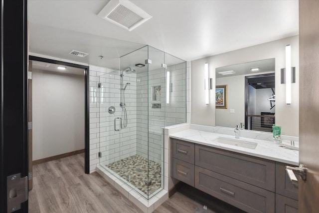 bathroom featuring a shower with door, vanity, and wood-type flooring