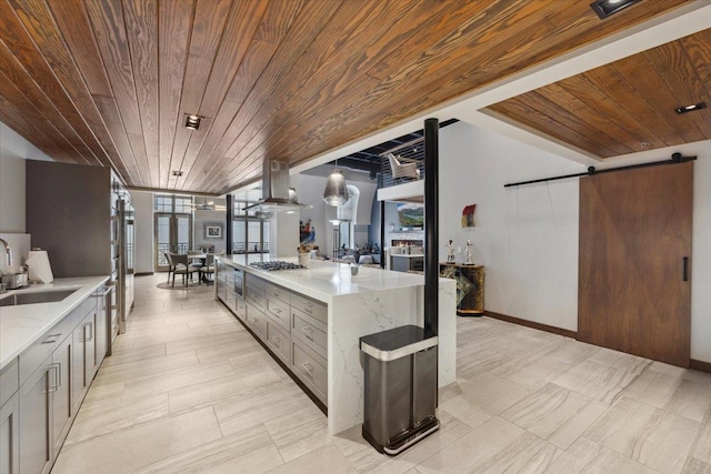 kitchen with wooden ceiling, a barn door, wall chimney range hood, and floor to ceiling windows