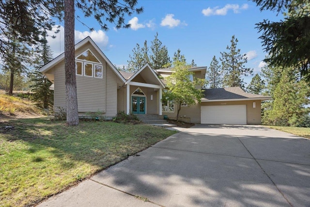 view of front of home with driveway, french doors, a front lawn, and an attached garage