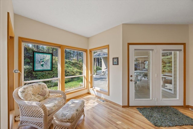 sitting room featuring baseboards, visible vents, and light wood-style floors