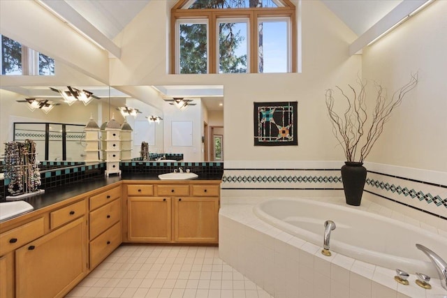 full bathroom with high vaulted ceiling, tile patterned floors, vanity, and a bath