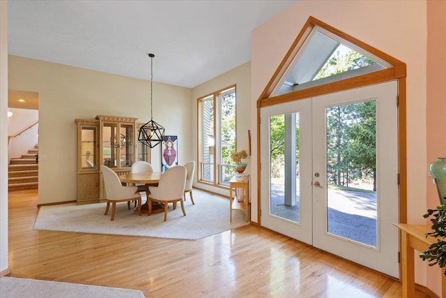 doorway with stairway, vaulted ceiling, wood finished floors, and french doors