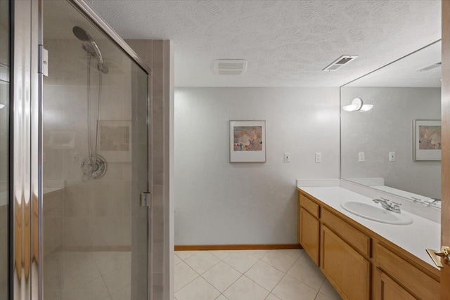 full bath featuring a stall shower, baseboards, vanity, and a textured ceiling