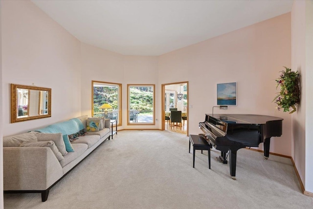 living room with a high ceiling, carpet flooring, and baseboards