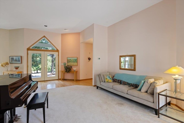 living room featuring lofted ceiling, baseboards, wood finished floors, and french doors