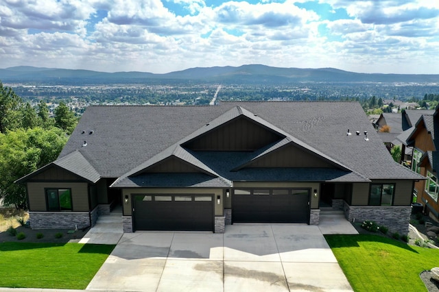 craftsman house with a garage, a front lawn, and a mountain view