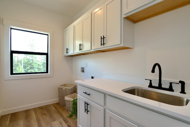 washroom with sink, washer hookup, cabinets, light wood-type flooring, and electric dryer hookup