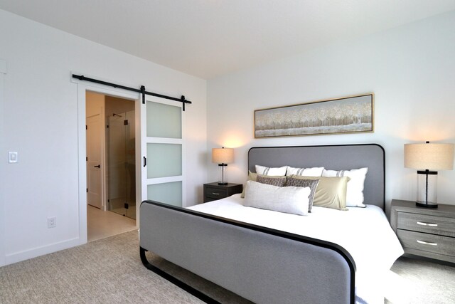 bedroom featuring light colored carpet and a barn door