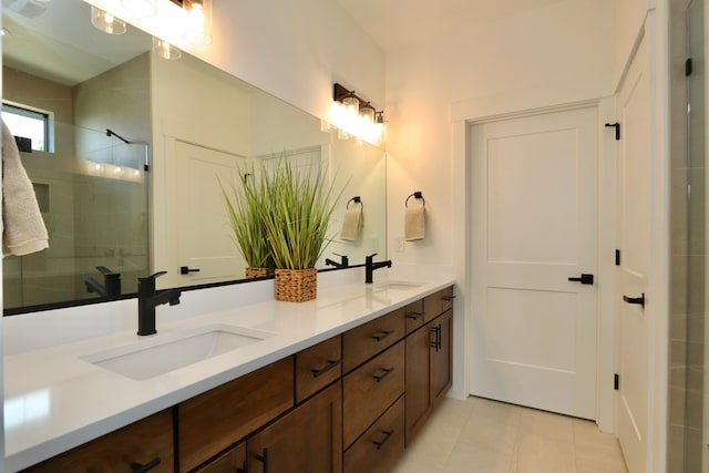 bathroom with tile patterned floors, a tile shower, and vanity