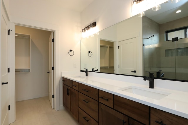 bathroom with tile patterned flooring, a shower with door, and vanity