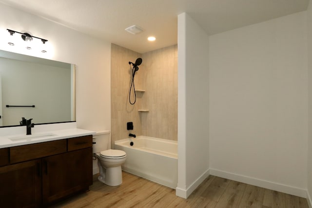 full bathroom featuring tiled shower / bath combo, wood-type flooring, toilet, and vanity