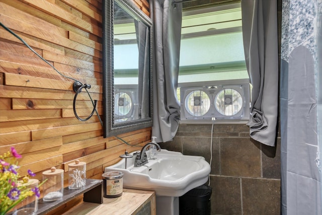 bathroom with sink and wooden walls