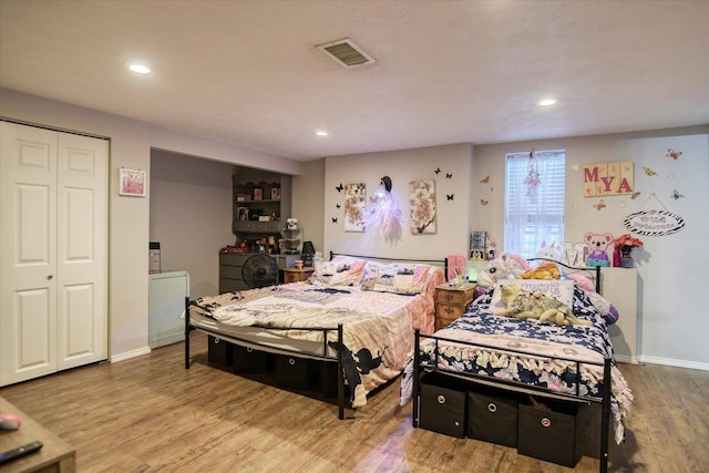 bedroom with hardwood / wood-style flooring and a closet