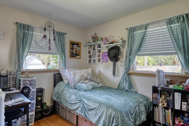 bedroom with multiple windows and light wood-type flooring