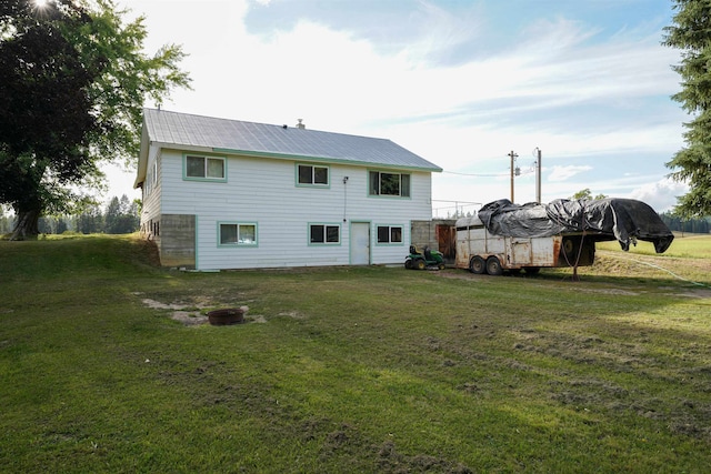 back of property featuring a yard and an outbuilding